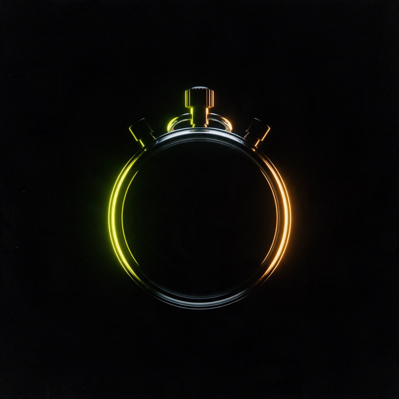 A chrome stopwatch face on, its bezel rim-lit lime and amber